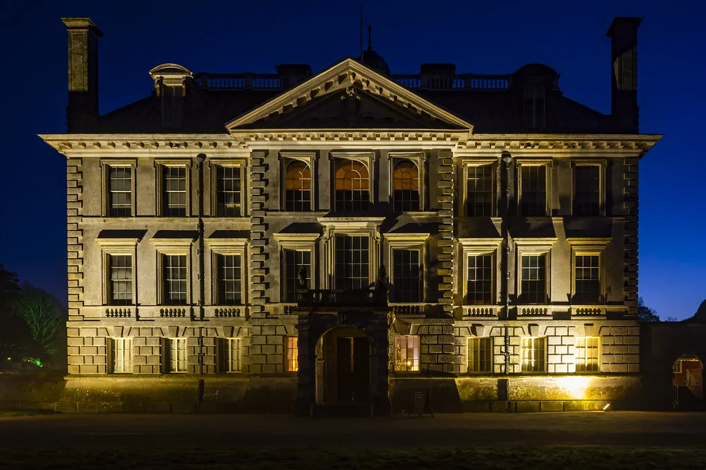 Stone estate facade washed with warm architectural lighting at night
